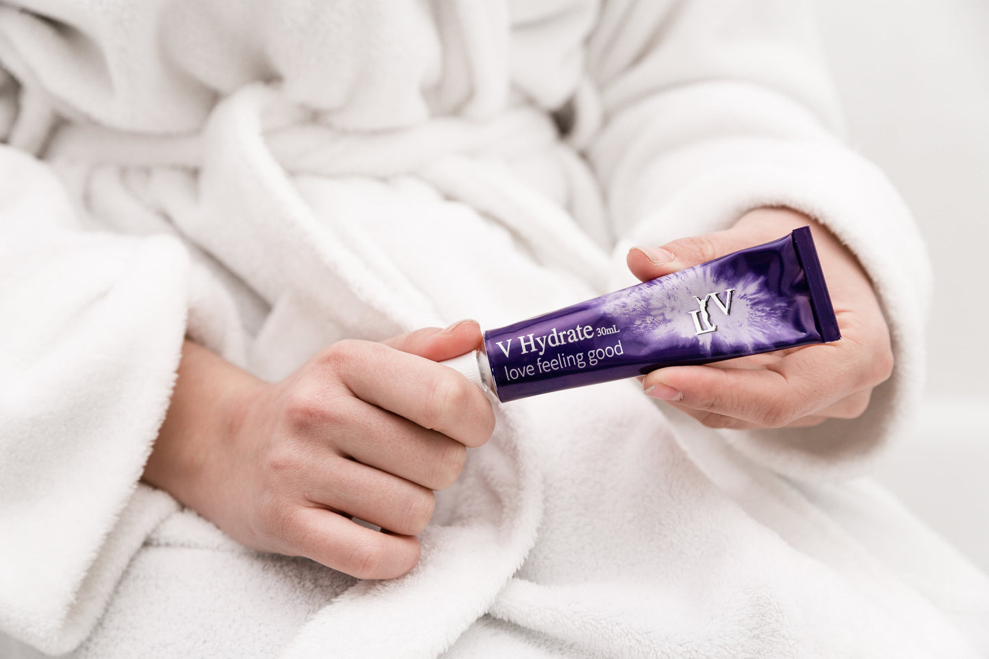 LYV V-Hydrate intimate moisturiser tube, held in a robe